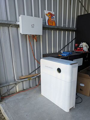 Temporary Sigenergy off-grid solar setup installed in Kempsey, NSW, showing a wall-mounted inverter and floor-standing battery unit inside a shed.