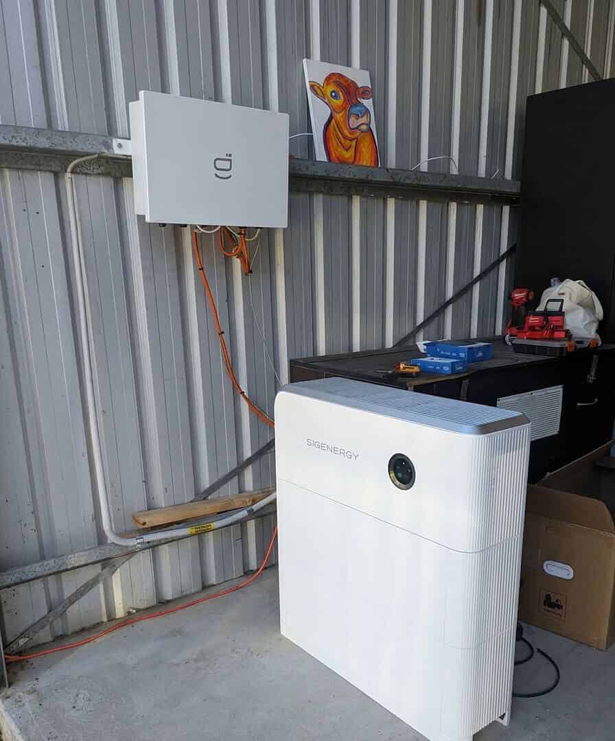 Temporary Sigenergy off-grid solar setup installed in Kempsey, NSW, showing a wall-mounted inverter and floor-standing battery unit inside a shed.