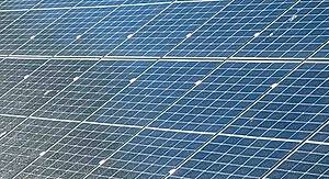 Large solar panel installation showing multiple rows of photovoltaic panels with visible mounting frames and connections