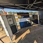 Trade show display featuring Pylontech battery systems, solar panels, and energy storage equipment under marquee tent