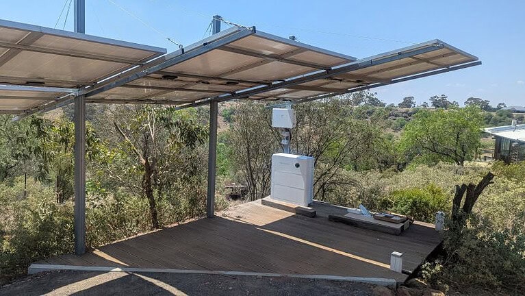 A modern solar and battery setup with solar panels also functioning as carport cover