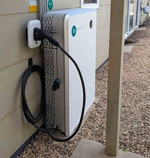 White Sigenergy DC EV charger mounted on wall with charging cable, part of off-grid solar system near Daylesford Victoria
