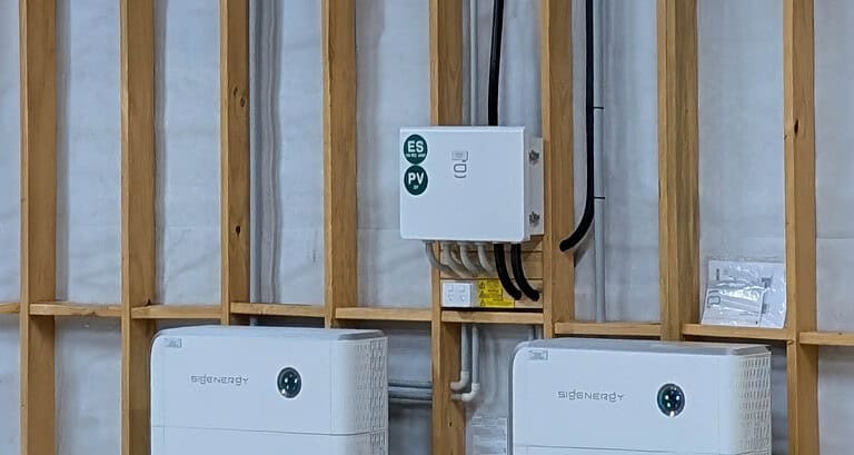 Sigenergy Gateway switchboard mounted on timber frame wall with two battery units below during off-grid solar installation