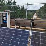 Solar panels and control cabinet behind security fencing at an off-grid installation in rural Victoria