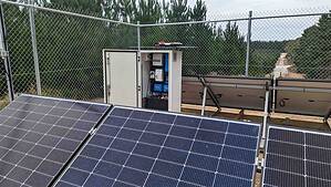 Solar panels and control cabinet behind security fencing at an off-grid installation in rural Victoria