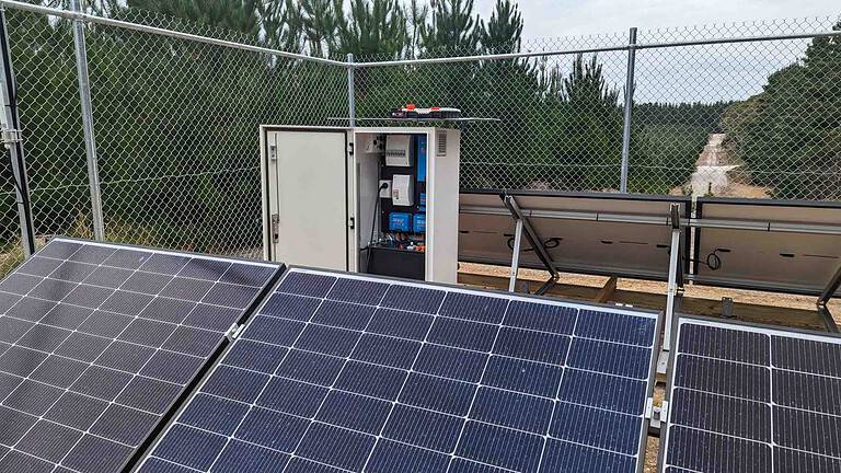 Solar panels and control cabinet behind security fencing at an off-grid installation in rural Victoria