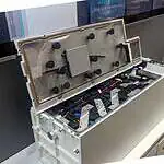 White lithium battery housing opened to show internal cell configuration with mounting brackets and wiring connections