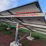 Ground-mounted solar panels on tracking system that tilts to follow sun movement, with red text overlay about energy pricing