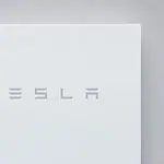 Tesla Powerwall home battery unit mounted on wall showing clean white design with Tesla branding