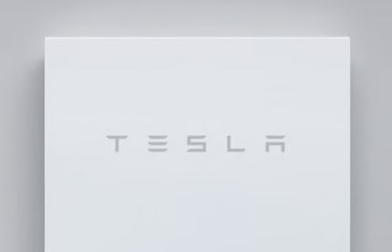 Tesla Powerwall home battery unit mounted on wall showing clean white design with Tesla branding