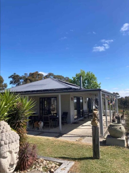 Rural home with rooftop solar panels and outdoor living area showing integrated off grid energy system